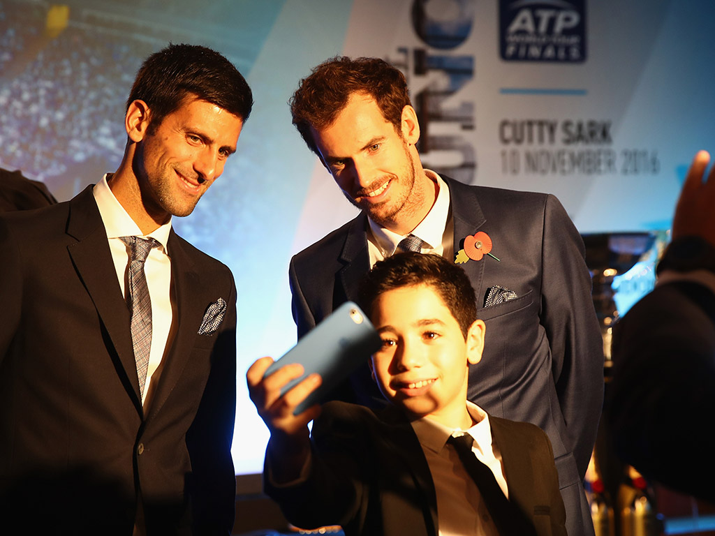 A lucky young fan gets a selfie with Novak Djokovic (L) and Andy Murray; Getty Images