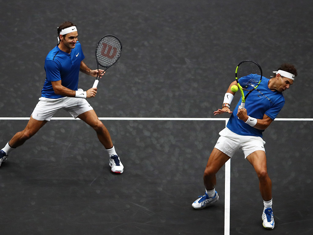 Roger Federer (L) looks on in amusement as Rafael Nadal is targeted at net; Getty Images